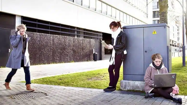 Trois personnes et une armoire électrique urbaine