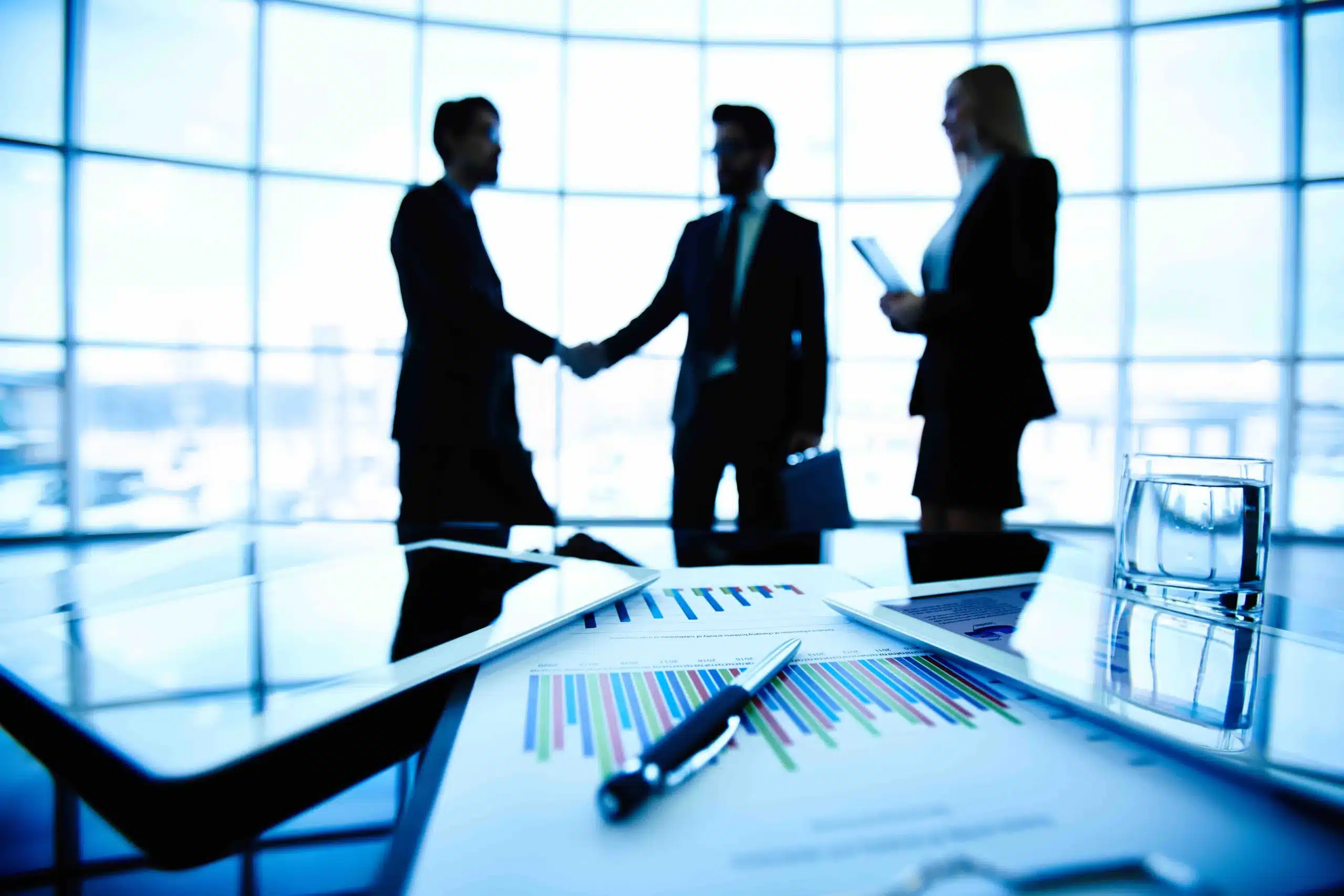 close-up-bar-graph-with-executives-negotiating-background-compressed Négociation